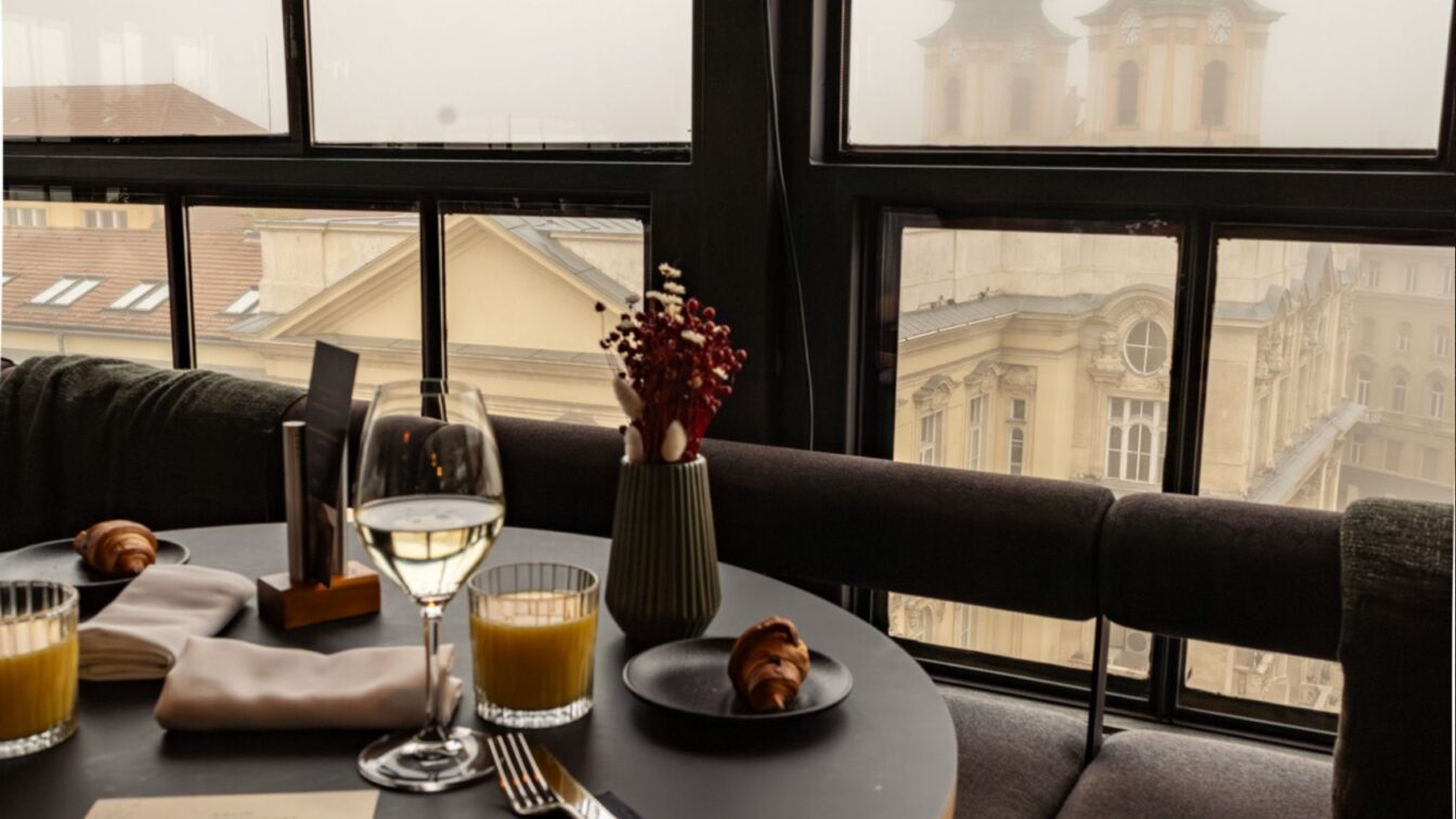 (c) Sonja Koller | 1000things Stilvoll gedeckter Frühstückstisch in einem der besten Hotels Budapests mit Blick auf historische Fassaden und nebelverhangene Kirchtürme – elegantes Ambiente über den Dächern der Stadt