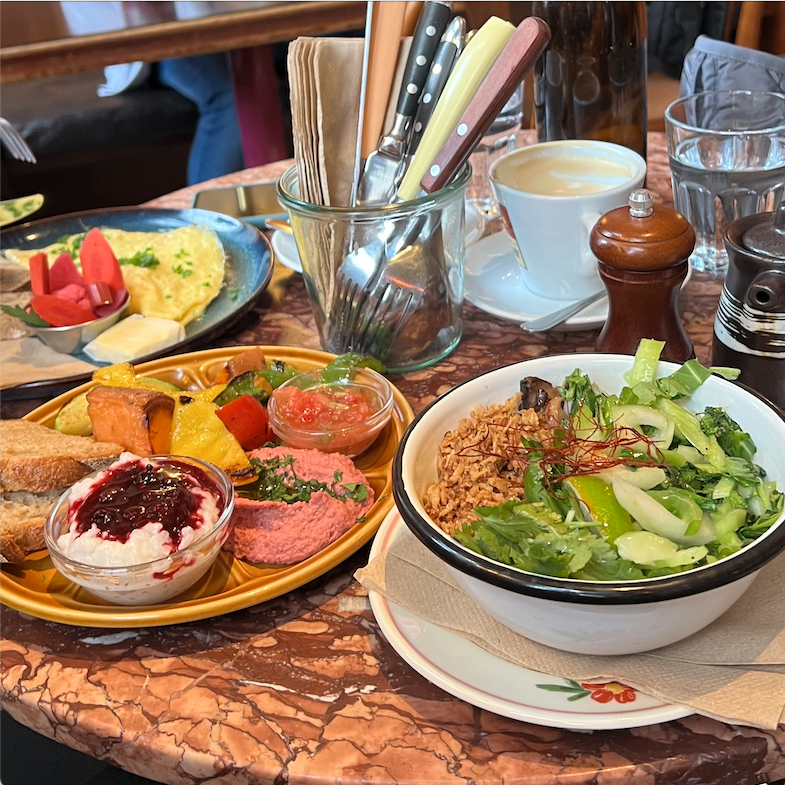 voller Frühstückstisch im Café Kriemhild, Eierspeis, gegrilltes Gemüse mit Hummus und MIlchreis, Congee