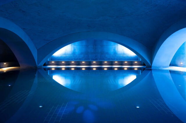 Foto eines Indoor-Pools mit gedimmter und blauer Licht-Atmosphäre