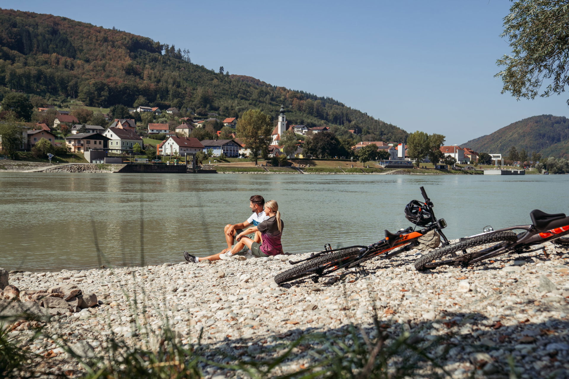 Menschen mit Rad an der Donau (c) WGD Donau Oberösterreich Tourismus GmbH | Studio Draussen
