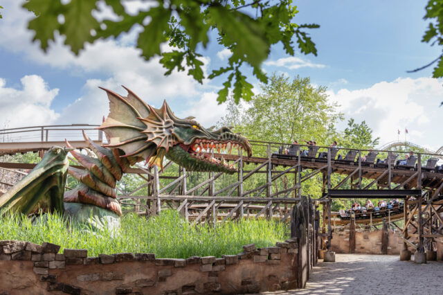 Ein Drachenkopf mit Achterbahn im Hintergrund im Efteling Freizeitpark.