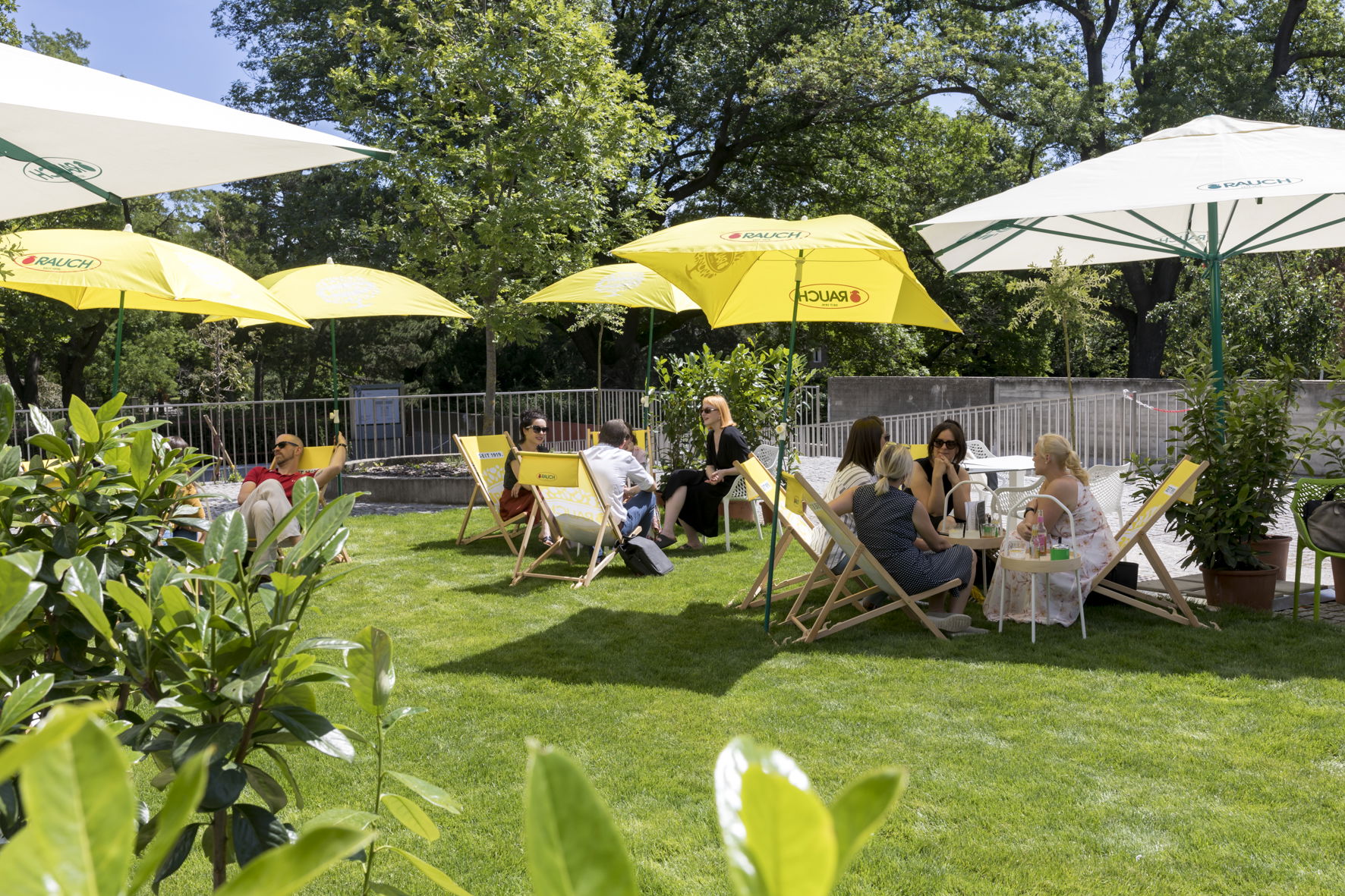 Menschen sitzen in Liegestühlen im Gastgarten der Lucy Bar im Belvedere