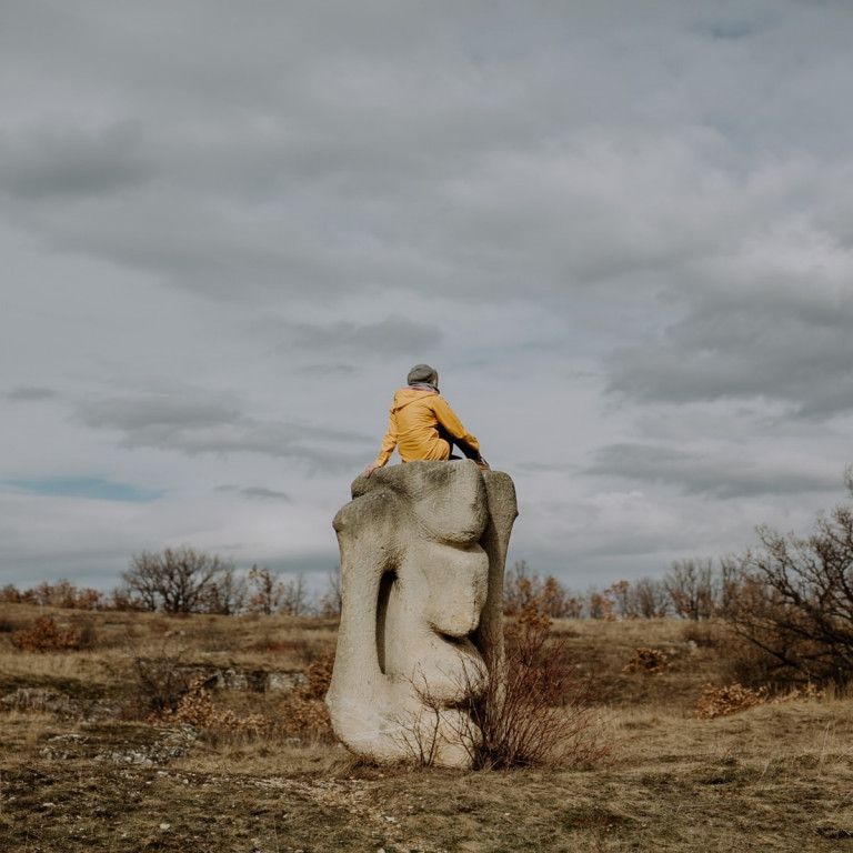 © Ines Futterknecht Person sitzt auf Skulptur